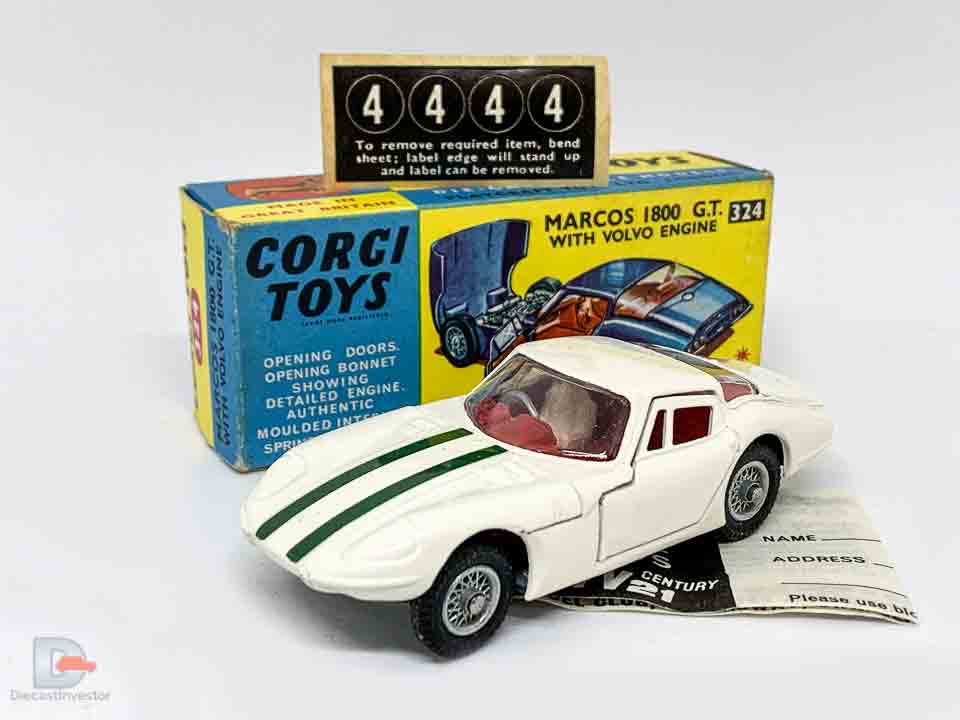 Corgi 324 Marcos 1800 GT - white body with green engine stripes, red interior with figure driver, wire wheels - Excellent Plus still a beautiful example in an Excellent Plus blue and yellow carded picture box - also comes with collectors club folded leaflet and unapplied racing numbers. 